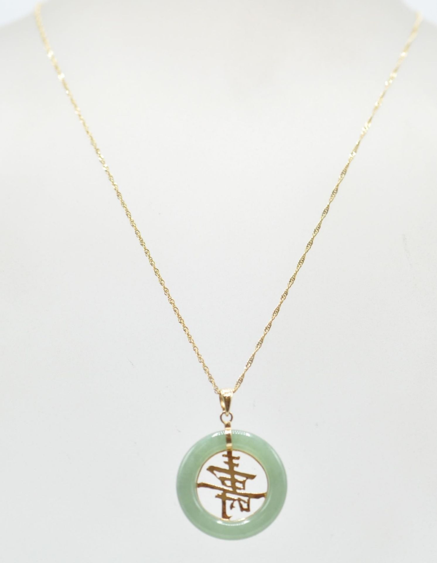 An 18ct gold necklace having a jade hoop and a gold chinese symbol set within. Chain measures