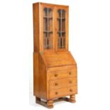 A 1930's Art Deco light oak bureau bookcase. The bookcase with a glazed double door enclosing