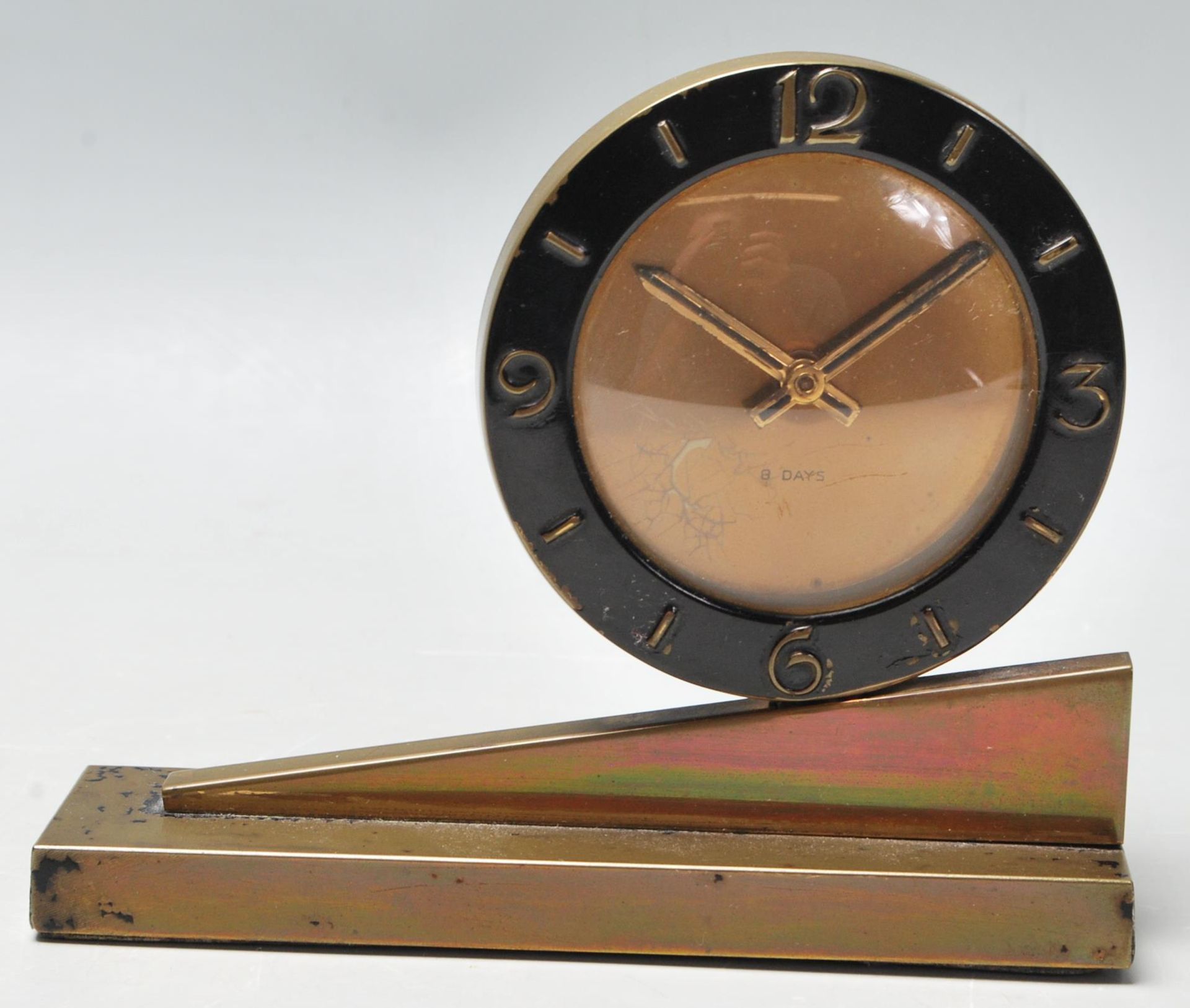 A 1920's Art Deco 8 days mantel clock having a round case with black enamelled case with arabic