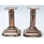 A pair of hallmarked sterling silver candlesticks with filled inner centres circular stems and set