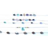 A group of five silver and glass bead necklaces each having silver clasps and spacers with