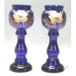 A pair of early 20th Century Bristol Blue vases hand painted with flowers and gilded detailing.
