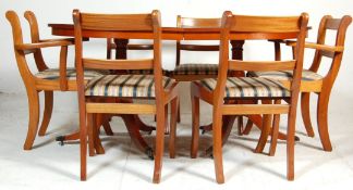 A Regency style mahogany twin pedestal dining table with extendable leaf, fluted sabre legs