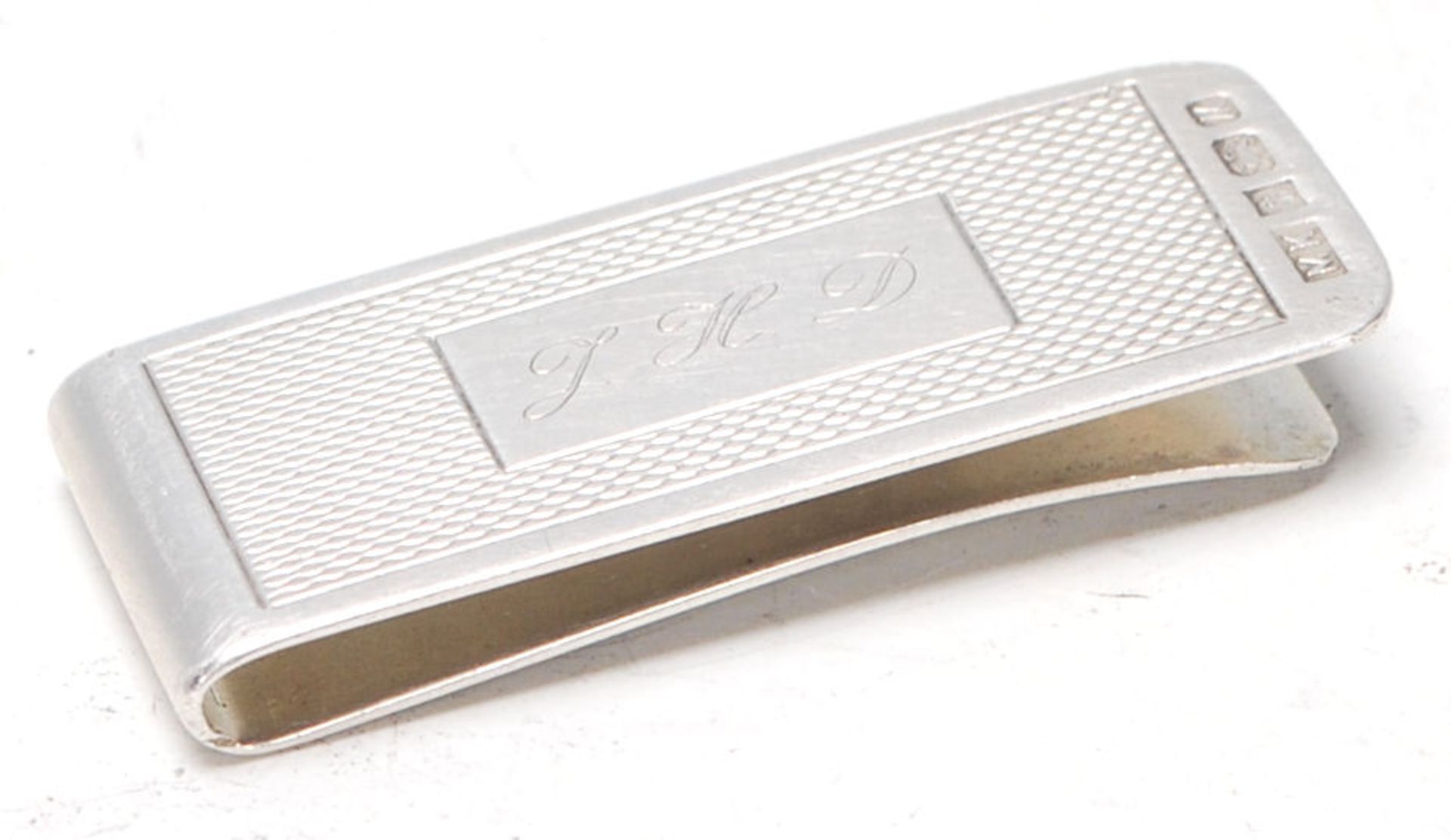 A vintage 20th Century silver hallmarked money clip having an engine turned panel to the front