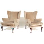 A pair of antique revival 20th century green fireside wing back armchairs upholstered in green