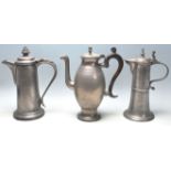 A group of three 19th century pewter jugs having hinged lid with spouted decoration atop.