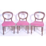 A set of three Victorian 19th century mahogany balloon back dining chairs having scroll carved back,