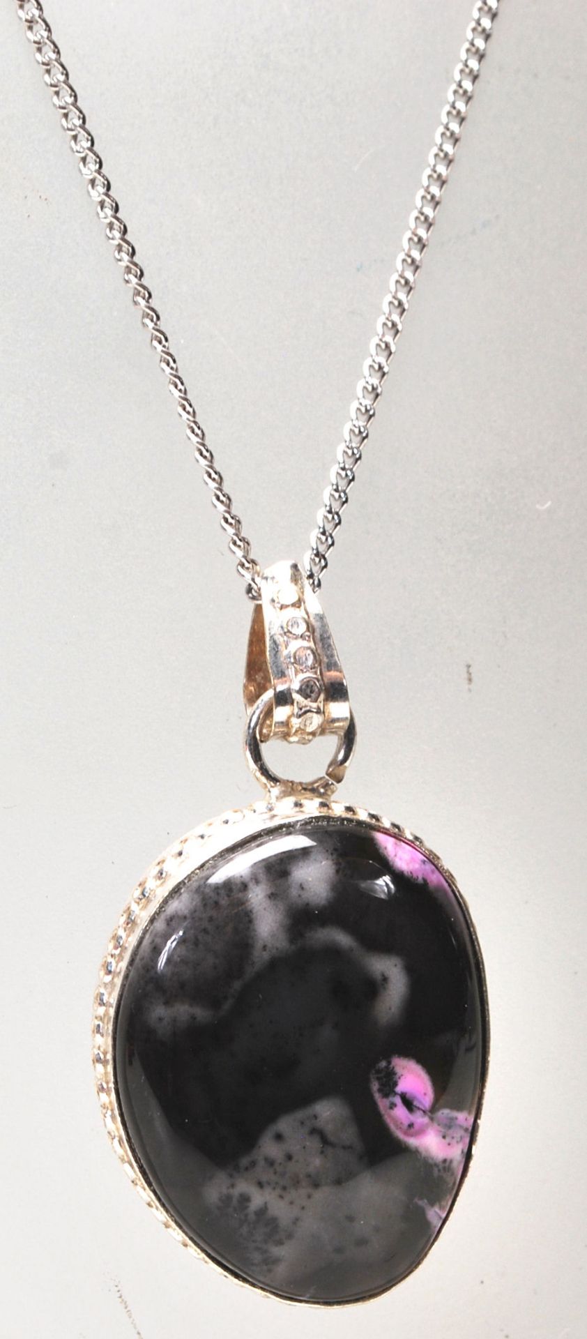 A silver and polychrome pendant necklace having a stone coloured in black and pink with a silver - Bild 2 aus 7