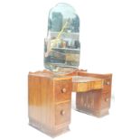 A 1930's Art Deco twin pedestal walnut dressing table. The dressing table with shaped bevelled