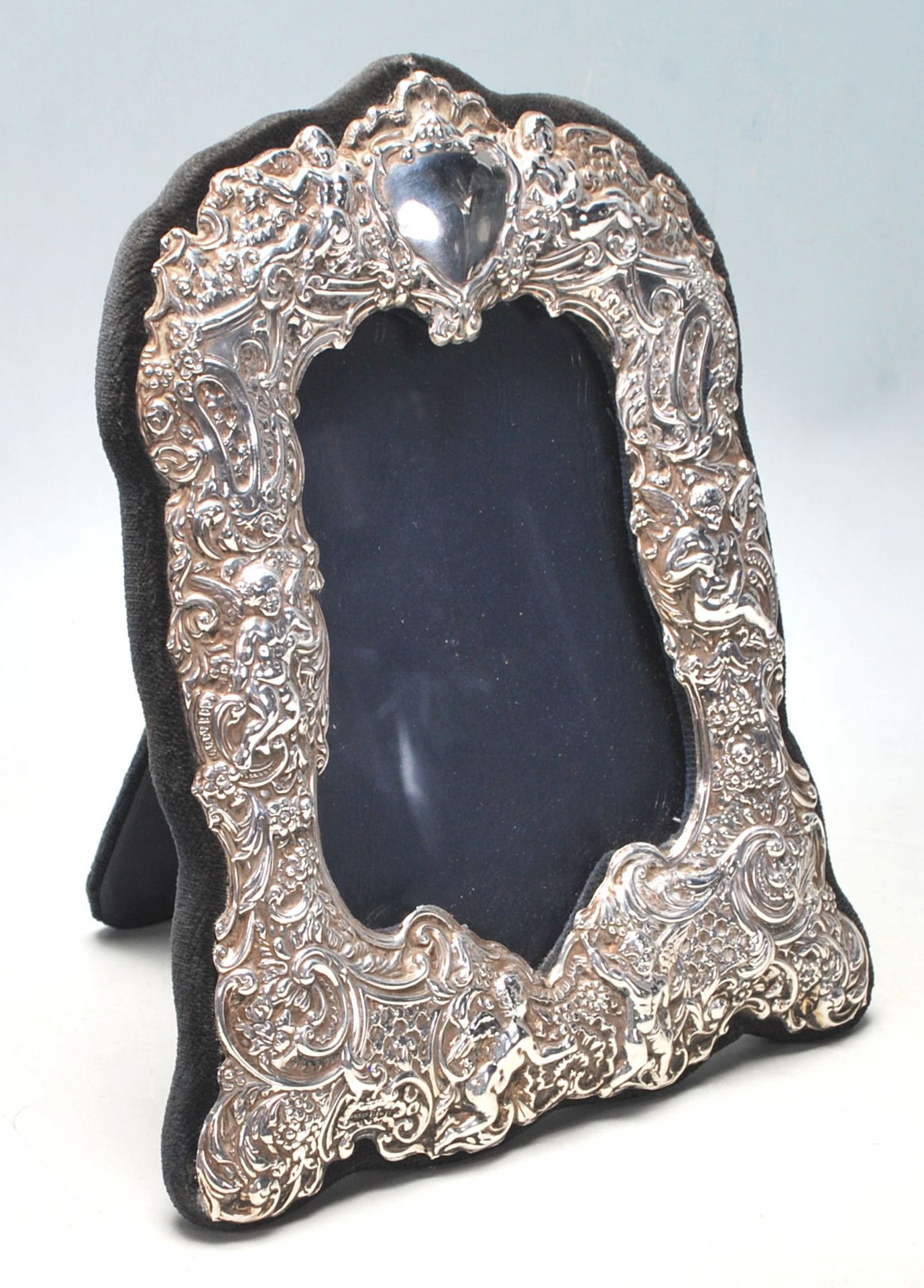 A contemporary hallmarked sterling silver picture frame with ornate decoration featuring a heart