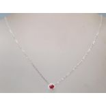 A 18ct white gold pendant necklace, the pendant having a central ruby with a halo of accent diamonds
