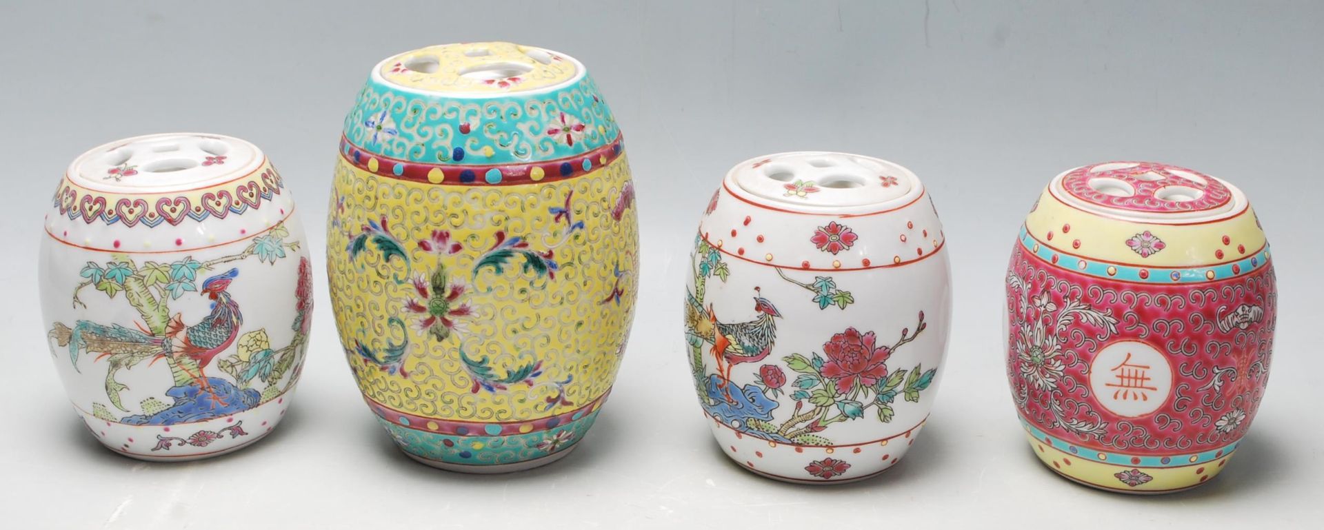 A group of four 20th Century Chinese storage jars of barrel form to include a red enamelled jar with