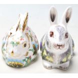A pair of Royal Crown Derby paperweights both in the shape of rabbits including Springtime Bunny &