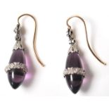 A pair of early 20th Century Edwardian amethyst and diamond drop earrings having polished amethyst