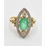 A hallmarked 18ct gold emerald and diamond ring. The ring having a pierced marquise shaped head