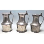 Three large 19th century pewter jugs having hinged lid with acorn decoration