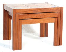 A 20th-century retro teak wood and tile top nest of three tables. The tables of graduating form