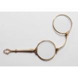 A 20th century gold plated spectacles with metamorphic actions engraved handle. Measure: 11cm long