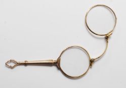 A 20th century gold plated spectacles with metamorphic actions engraved handle. Measure: 11cm long