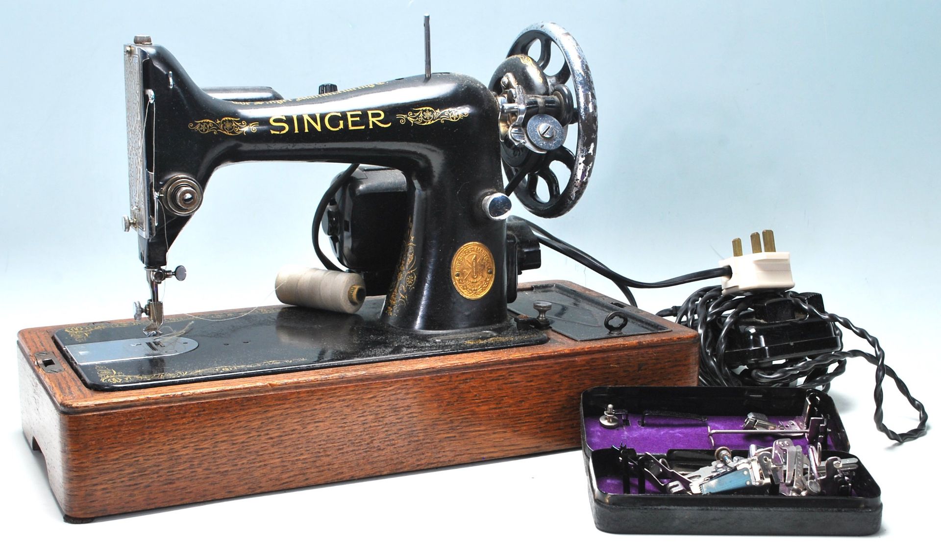 A vintage mid 20th Century Singer electric tabletop sewing machine having black body with gold