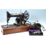 A vintage mid 20th Century Singer electric tabletop sewing machine having black body with gold