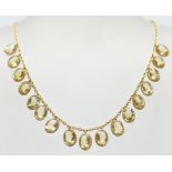A 20th Century antique 15ct gold and citrine necklace having a fine chain with seventeen oval cut