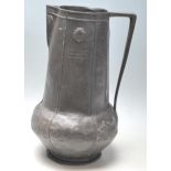 A early 20th century Art Nouveau pewter jug with tapered handle, bulbous form, sea shell raised