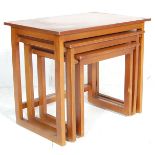 A 20th century nest of Danish inspired retro teak tables in the quadrille pattern. The tables each