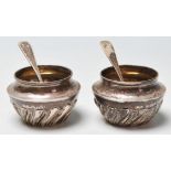 A pair of silver hallmarked table cruets / salt cellars of tapering form having gadrooned decoration