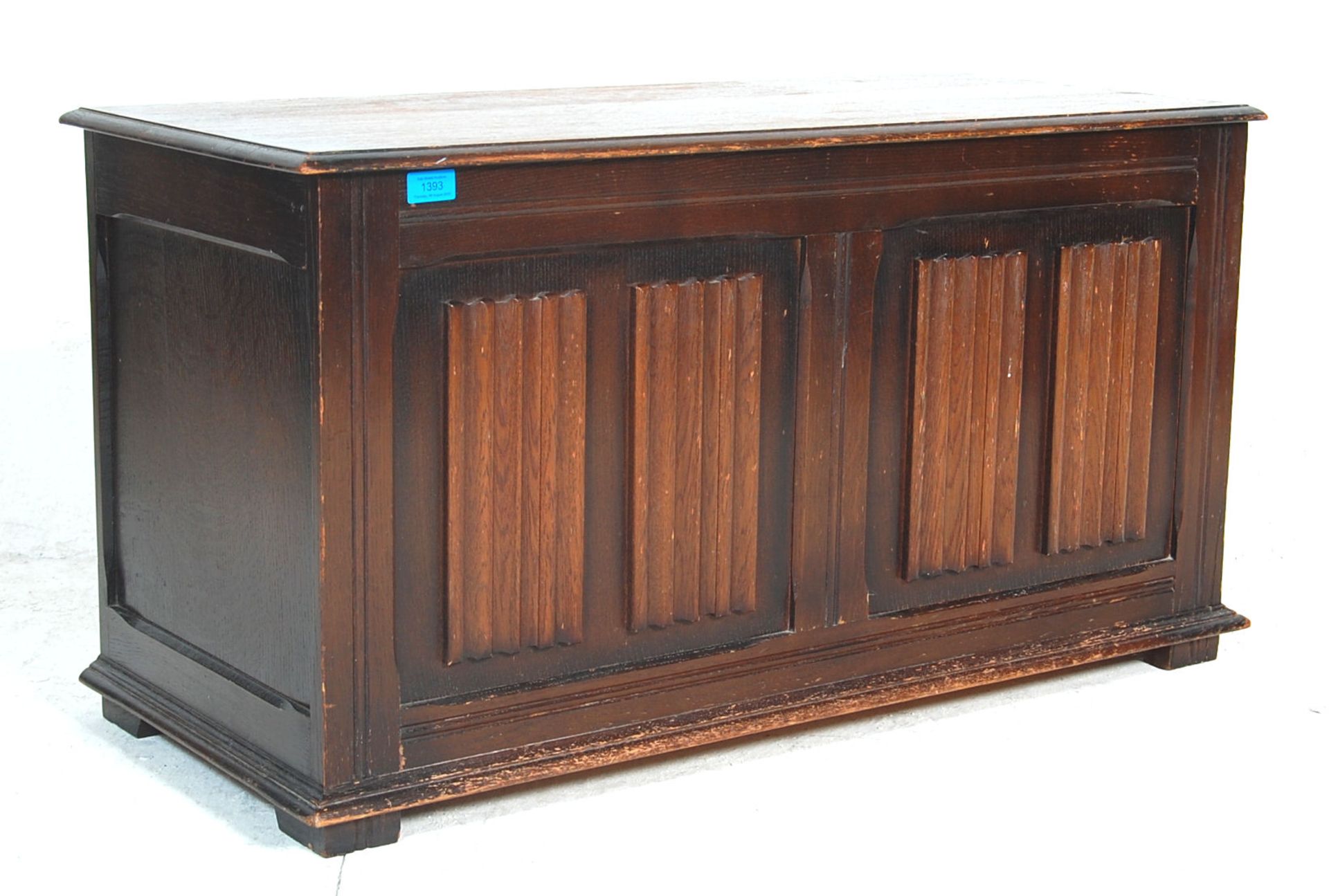 A mid century Jacobean revival oak blanket box/chest with hinged top over panelled sides with carved