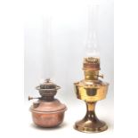 A pair of early 20th century brass oil lamps, one set on a circular base, both complete with glass