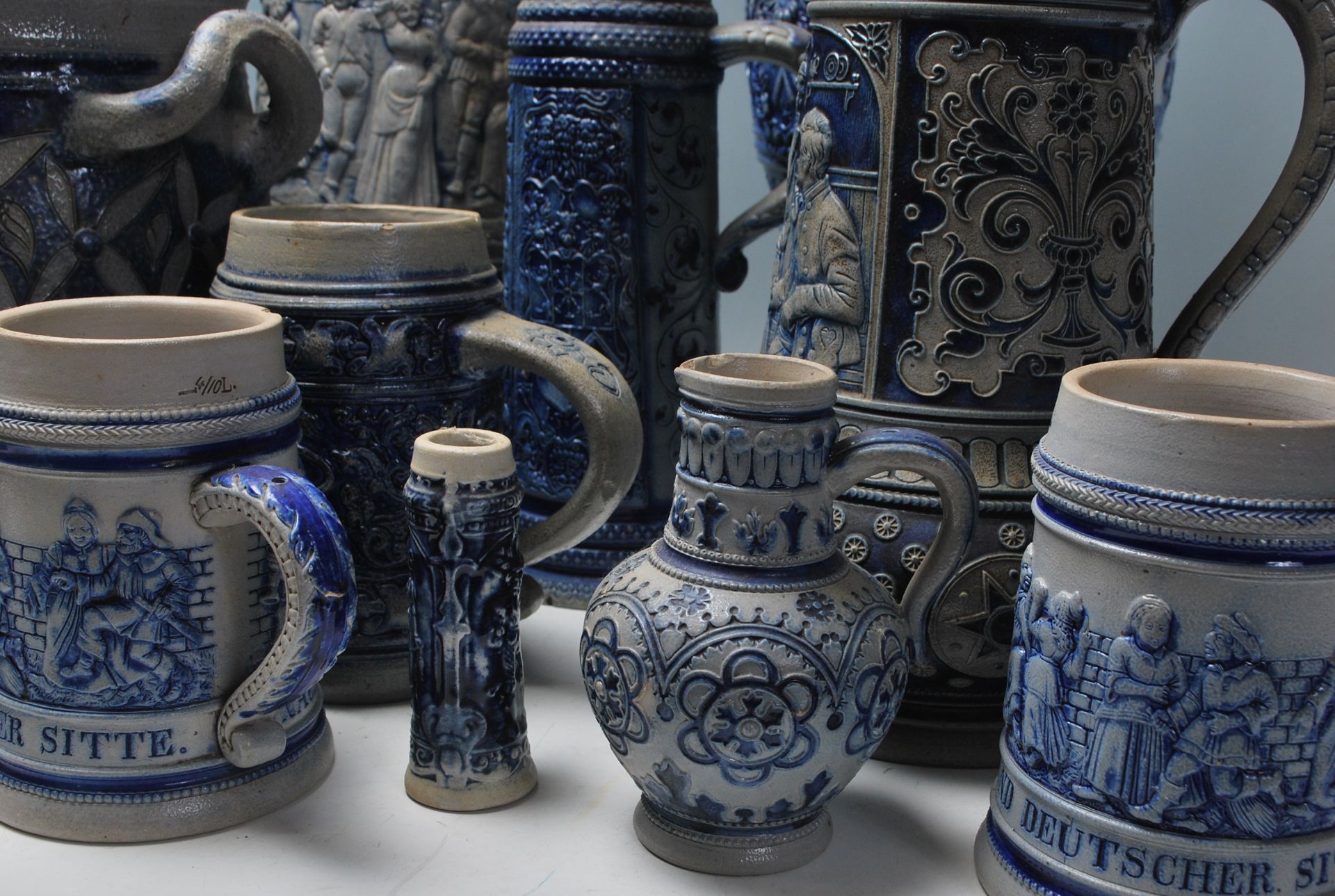 A collection of 20th Century German ceramic stein drinking glasses, each having raised decoration to - Bild 3 aus 7
