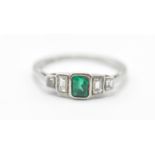 A platinum, emerald and diamonds ring having a central rectangular cut emerald flanked by four