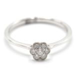 An 18ct white gold ladies dress ring in the shape of a flower having a central diamond set within