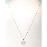 A 14ct mixed gold and diamond necklace having a pendant of square form with stones set within on a
