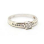 A hallmarked 9ct gold ring set with four square cut diamonds to the head with further accent
