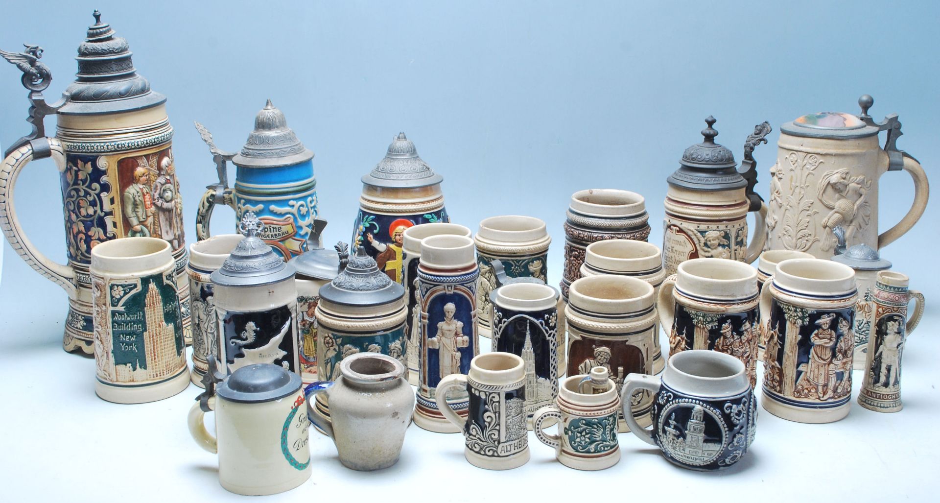 A large collection of German blue and grey stoneware jugs and beer steins, some having pewter