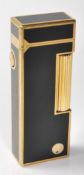 A vintage retro Dunhill lighter having black enamelled panels throughout with gilt borders, roller