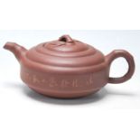 A 20th Century Chinese red clay Yi Xing teapot of round stepped form having a bamboo formed spout