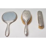 A silver hallmarked 1920's silver dressing table set to include a mirror, hair brush and clothes