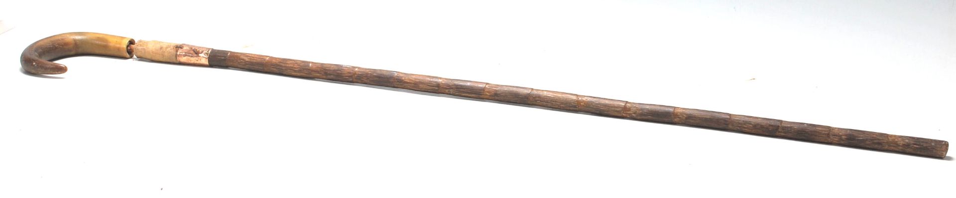 A 19th Century antique walking stick cane having a faux bamboo carved shaft with a gold collar and a