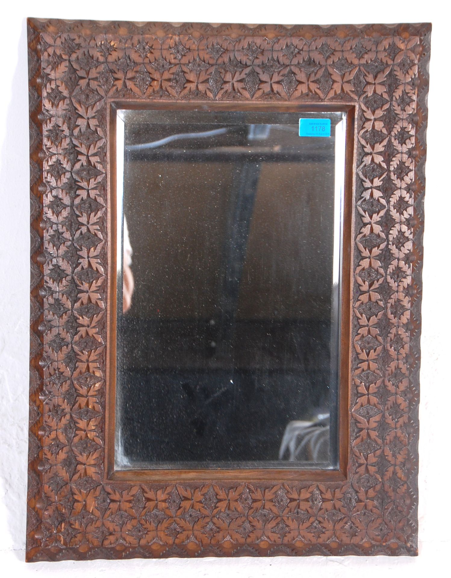A 20th Century overmantel - wall mirror having a central glass mirror and bevelled edge inset to a