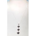 A stamped .925 silver pendant necklace having 3 vertical purple stones cased in silver with a silver