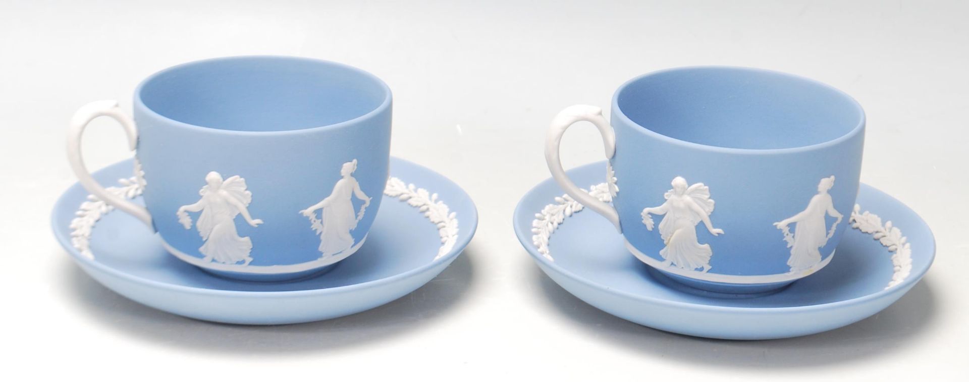 A pair of antique early 20th century Wedgwood dancing hours Jasperware tea cups and saucers with