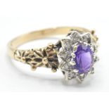 A hallmarked 9ct gold ladies dress ring being set with an oval cut purple stone with a halo of white