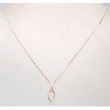 An 18ct rose gold necklace having a oval shaped pendant with a cluster of diamonds set within.