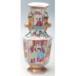 An early 20th Century Chinese Canton famille rose vase of faceted form having hand painted panels