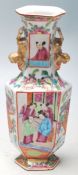 An early 20th Century Chinese Canton famille rose vase of faceted form having hand painted panels