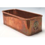 A vintage copper planter trough of rectangular form having a lipped edge and a lions head handle