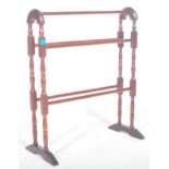 A 20th century Victorian revival mahogany arched towel rail raised on turned supports united by five